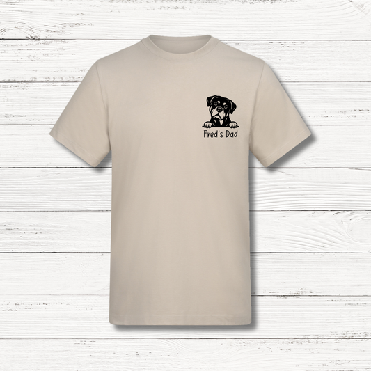 Beige t-shirt with a dog graphic and text on a wooden surface
