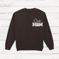 Black sweatshirt with 'Dog Mom' text on a wooden surface