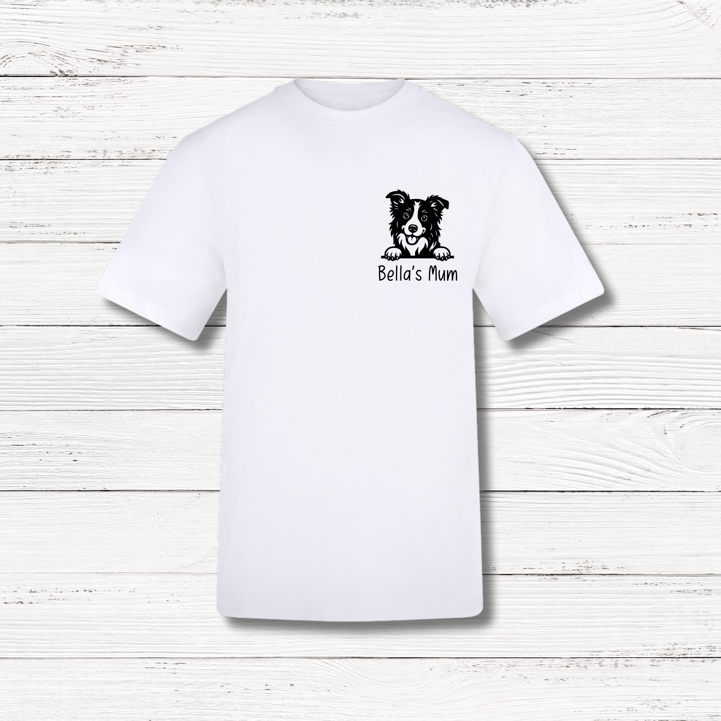 White t-shirt with a dog illustration and 'Bella's Mum' text on a wooden surface