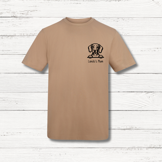 Beige t-shirt with a dog illustration and text on a wooden surface