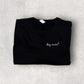 Folded black shirt with 'dog mama' text on a gray surface