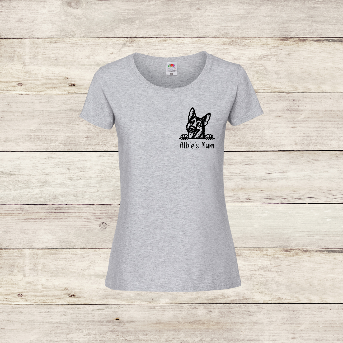Gray t-shirt with a black dog illustration and text on a wooden surface
