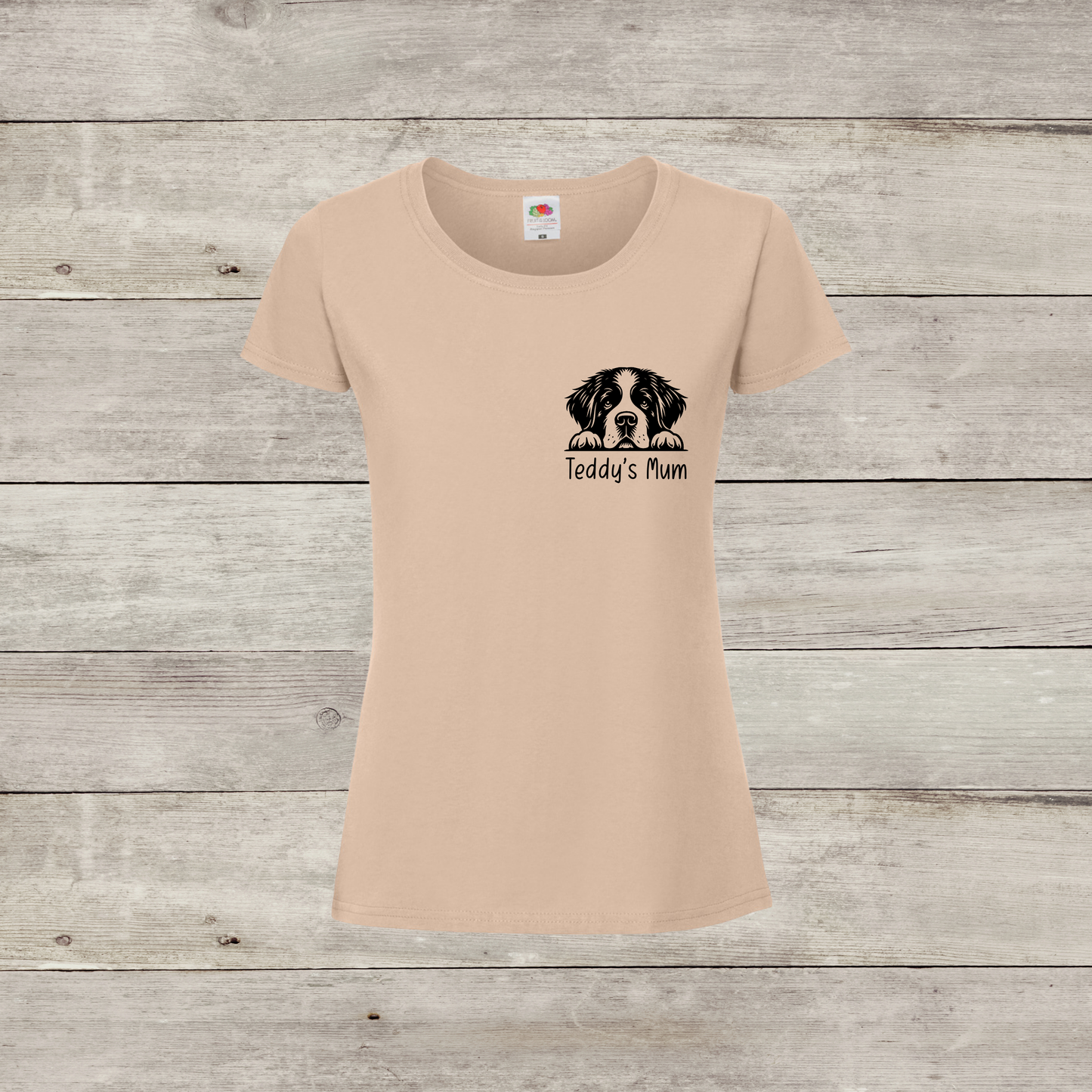 Beige t-shirt with a dog illustration and text on a wooden surface