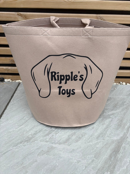 Beige bag with 'Ripple's Toys' logo on a textured wall background