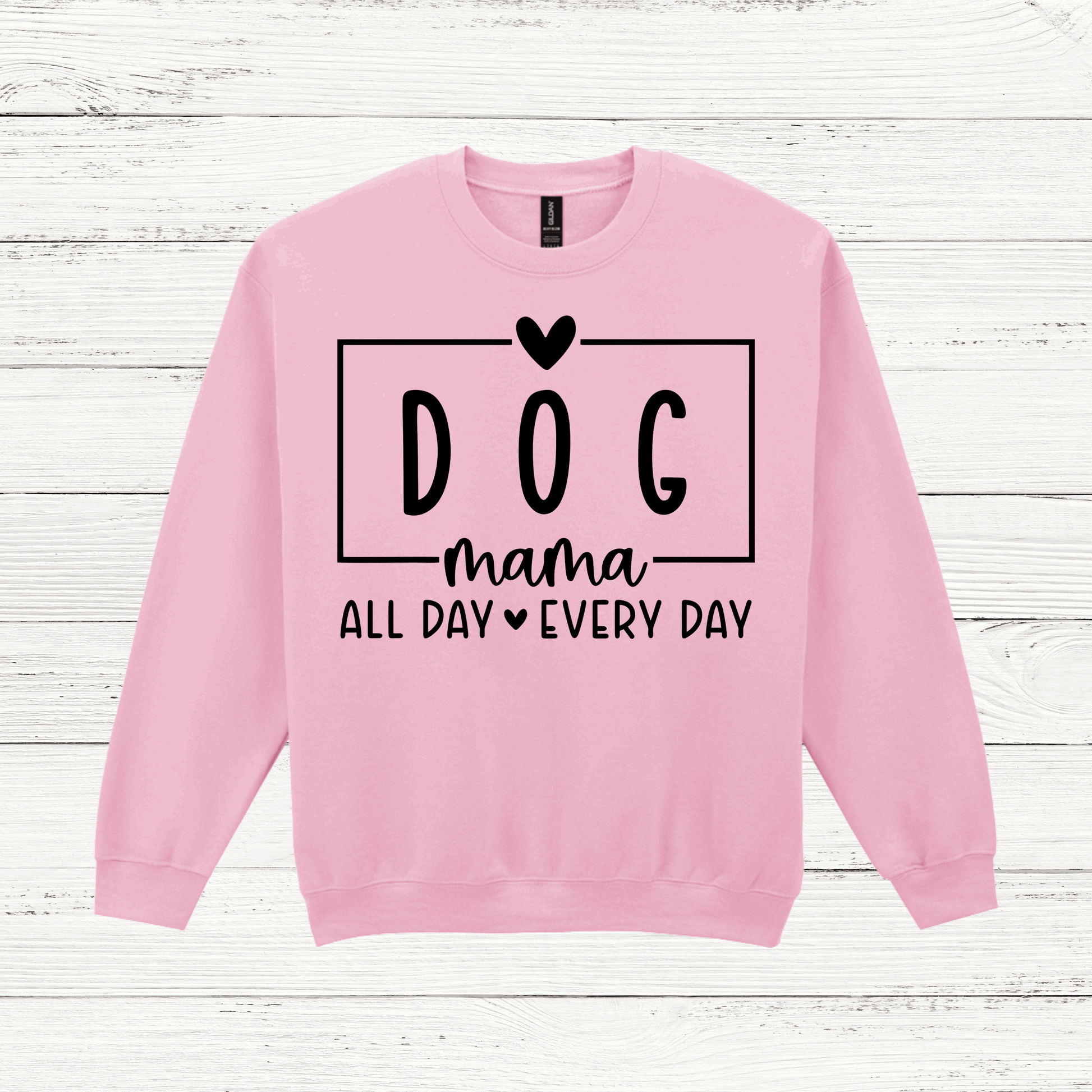 Pink sweatshirt with 'DOG mama ALL DAY EVERY DAY' text on a wooden surface