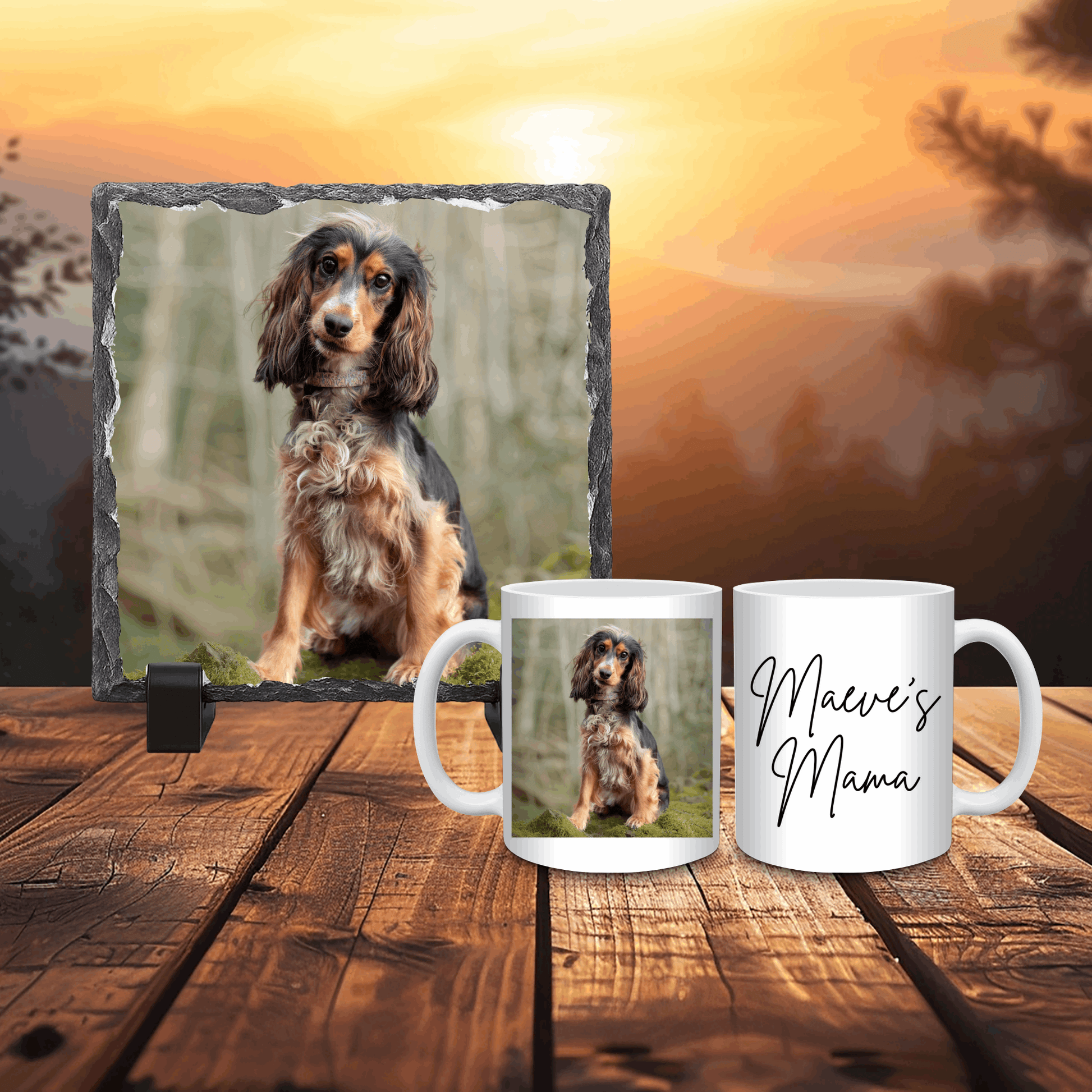 Two mugs with a dog photo and 'Maeve's Mama' text on a wooden surface with a sunset background.