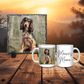 Two mugs with a dog photo and 'Maeve's Mama' text on a wooden surface with a sunset background.