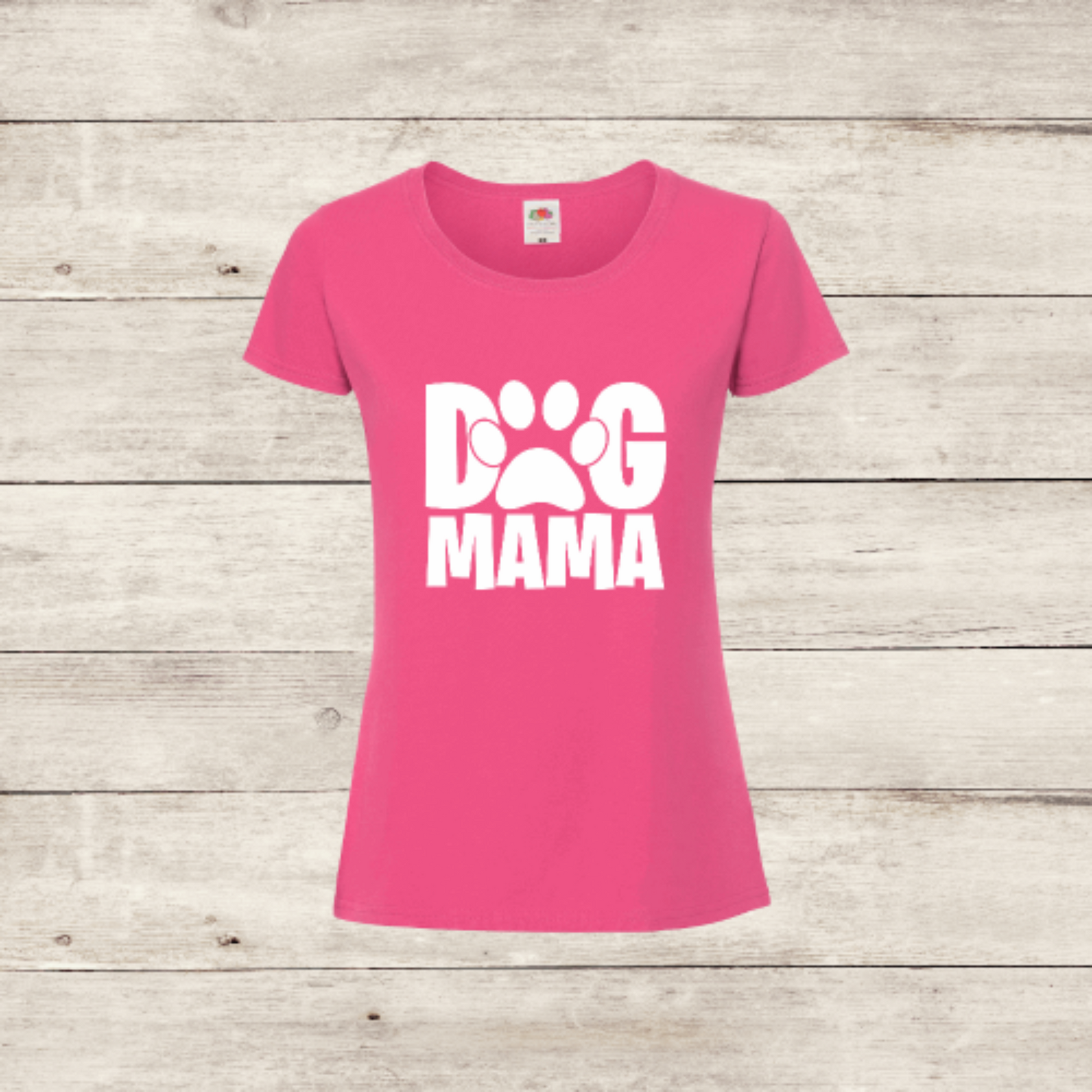 Pink t-shirt with 'Dog Mama' text on a wooden surface