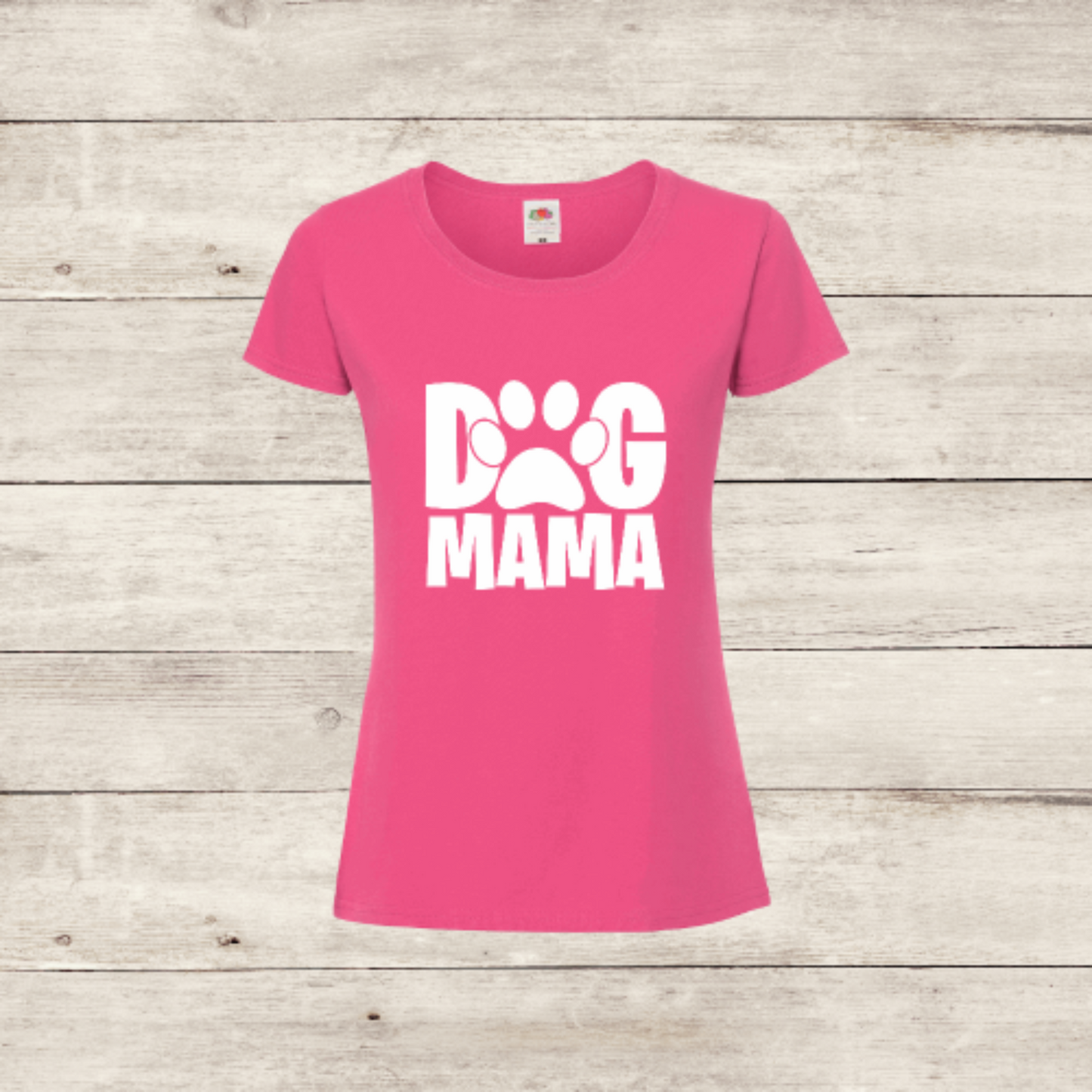 Pink t-shirt with 'Dog Mama' text on a wooden surface