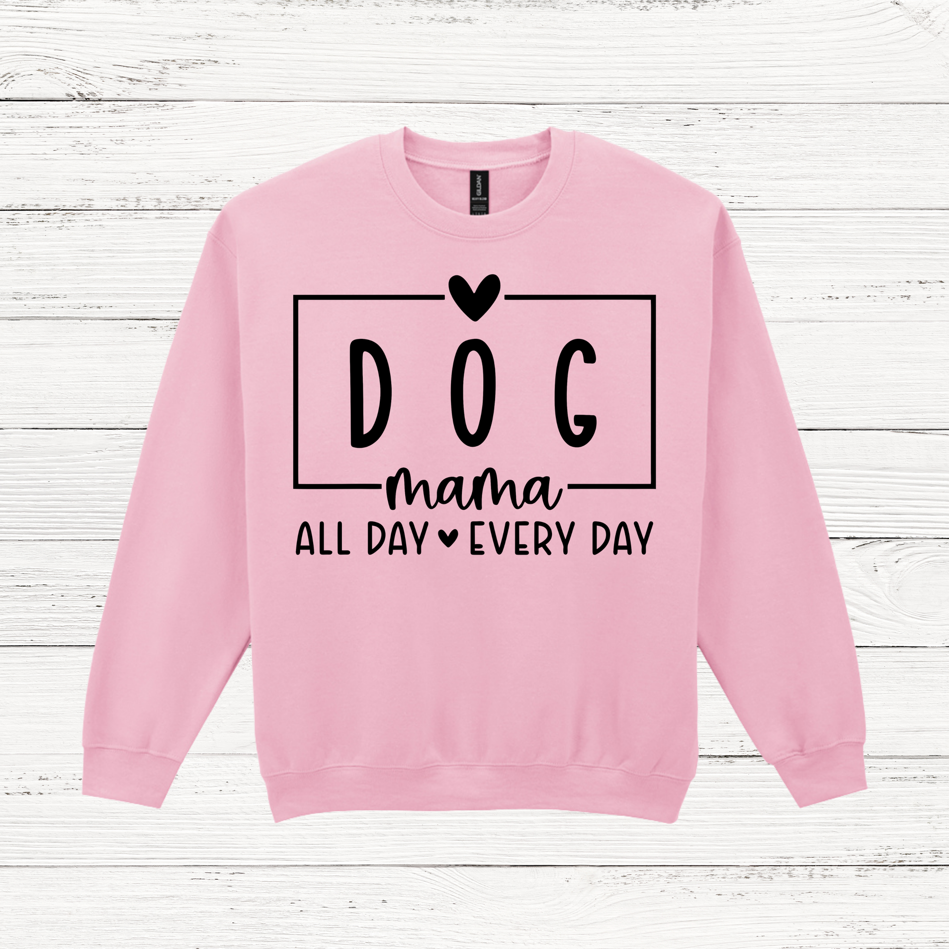 Pink sweatshirt with 'DOG mama ALL DAY EVERY DAY' text on a wooden surface