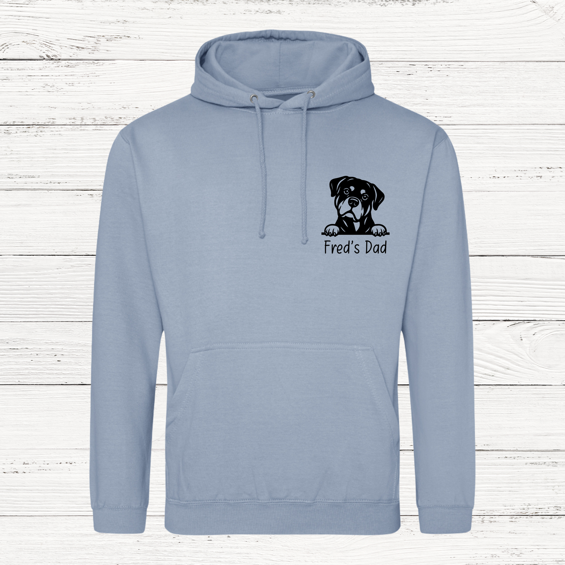 Light blue hoodie with a dog graphic and text on a wooden background