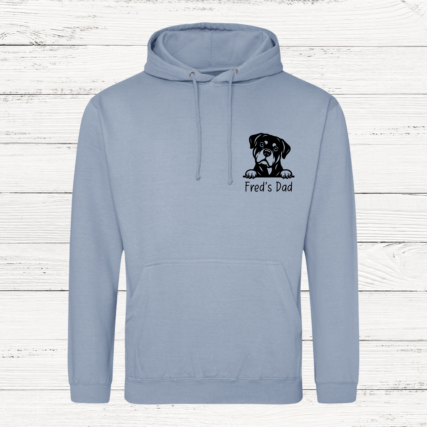 Light blue hoodie with a dog graphic and text on a wooden background