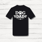 Black t-shirt with 'Dog Dad' text on a white wooden background