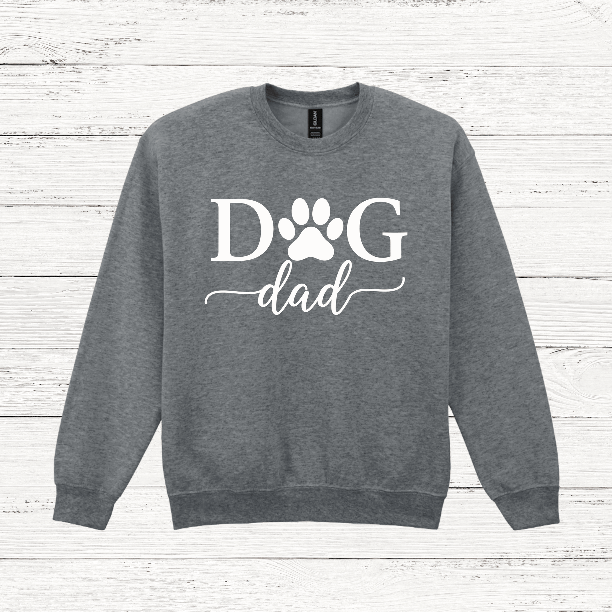 Gray sweatshirt with 'Dog Dad' text on a wooden surface