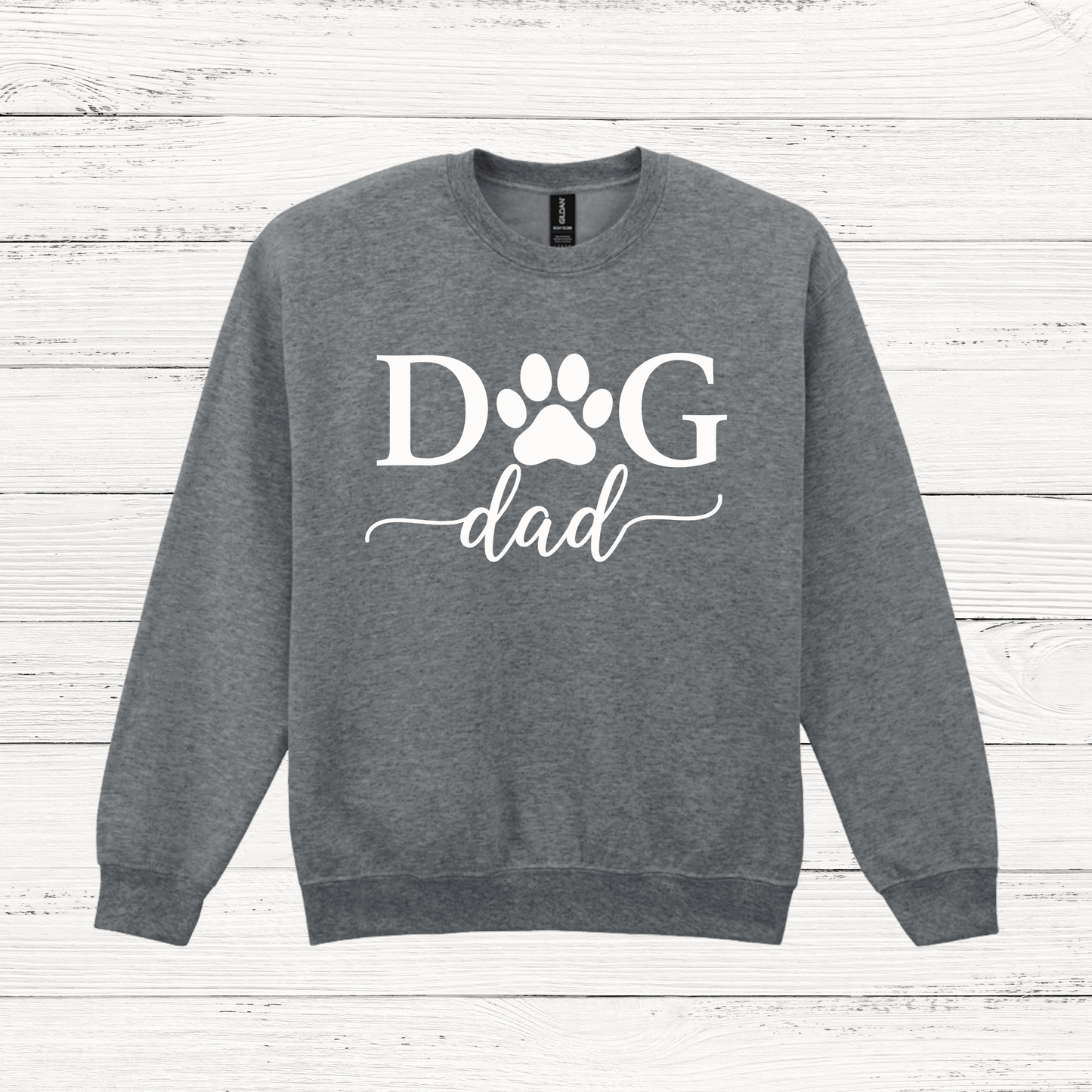 Gray sweatshirt with 'Dog Dad' text on a wooden surface