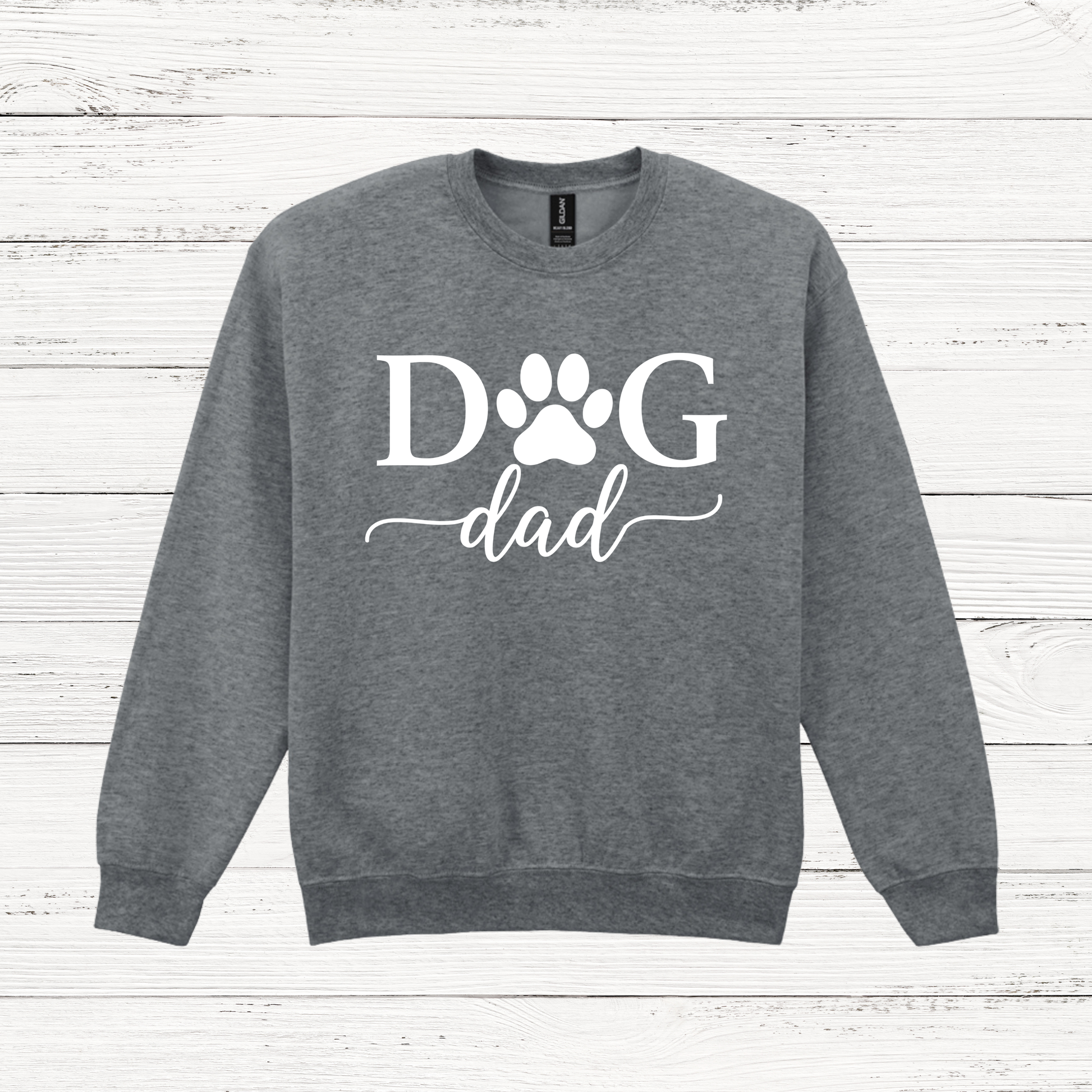 Gray sweatshirt with 'Dog Dad' text on a wooden surface