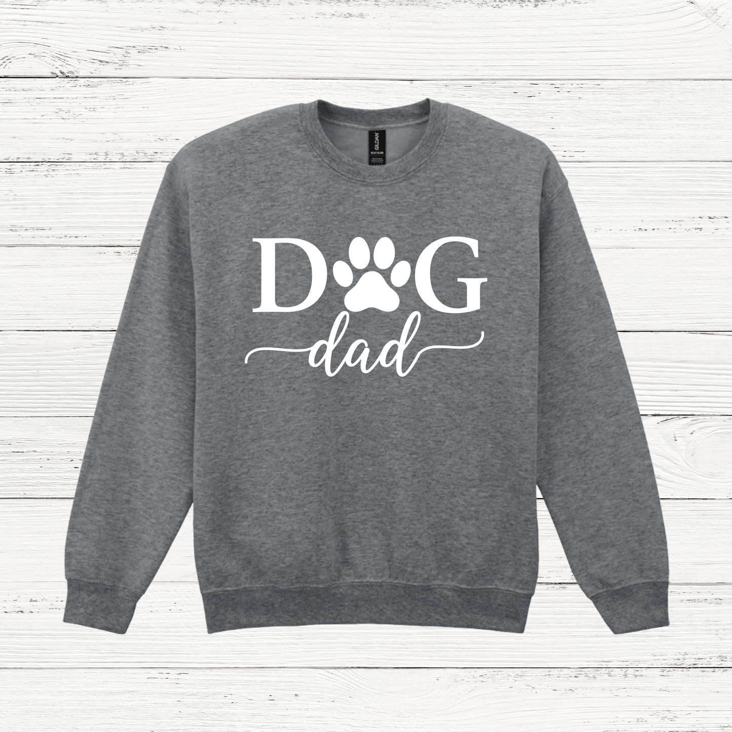 Gray sweatshirt with 'Dog Dad' text on a wooden surface