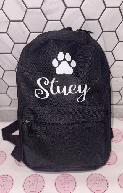 Black backpack with a paw print and 'Stuey' text on a tiled background