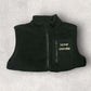 Black fleece gilet with 'Farmer Emmadee' text on a light gray background