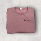 Folded mauve t-shirt with 'dog mama' text on a light gray surface