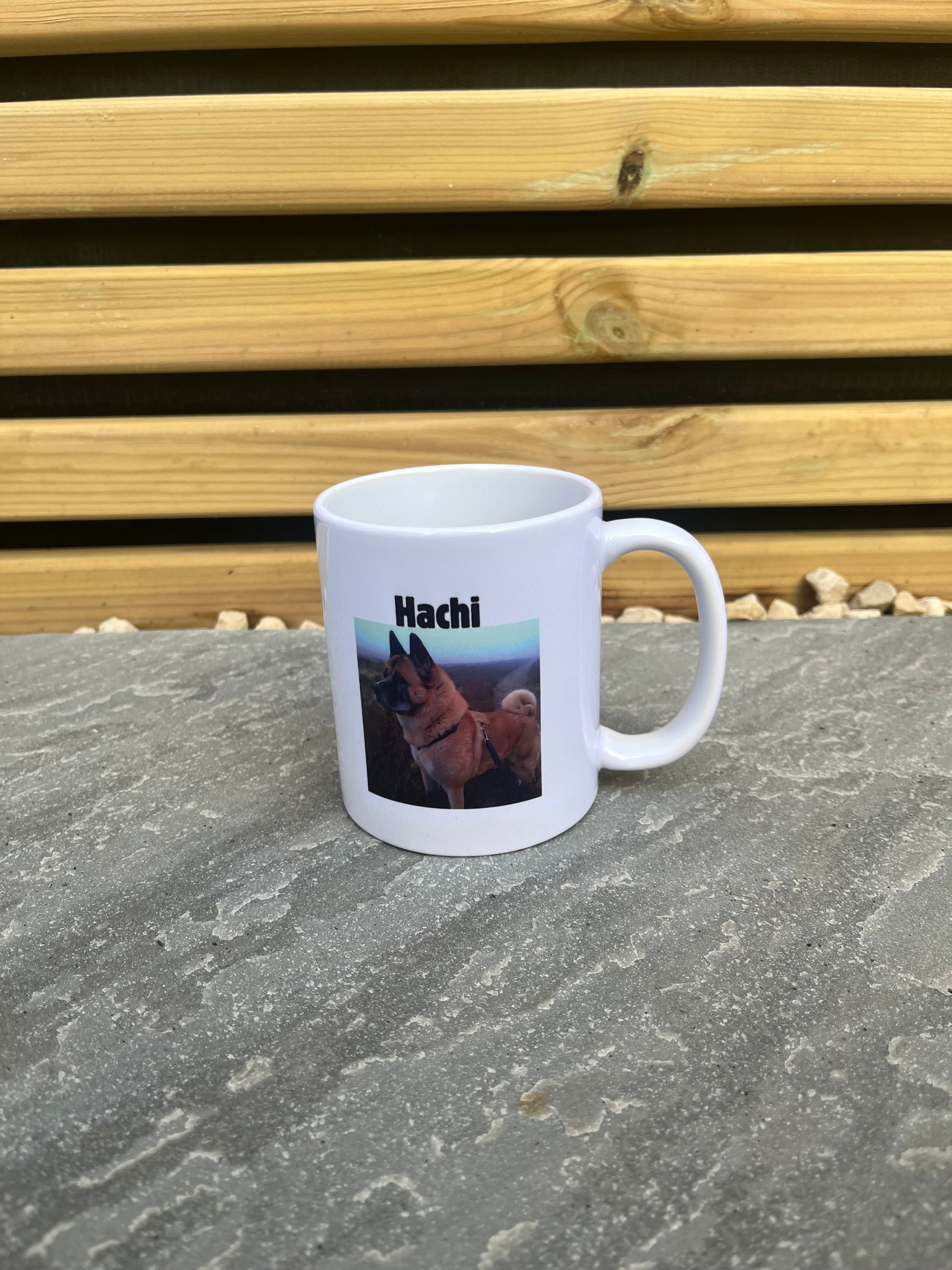 White mug with a printed design on a stone surface