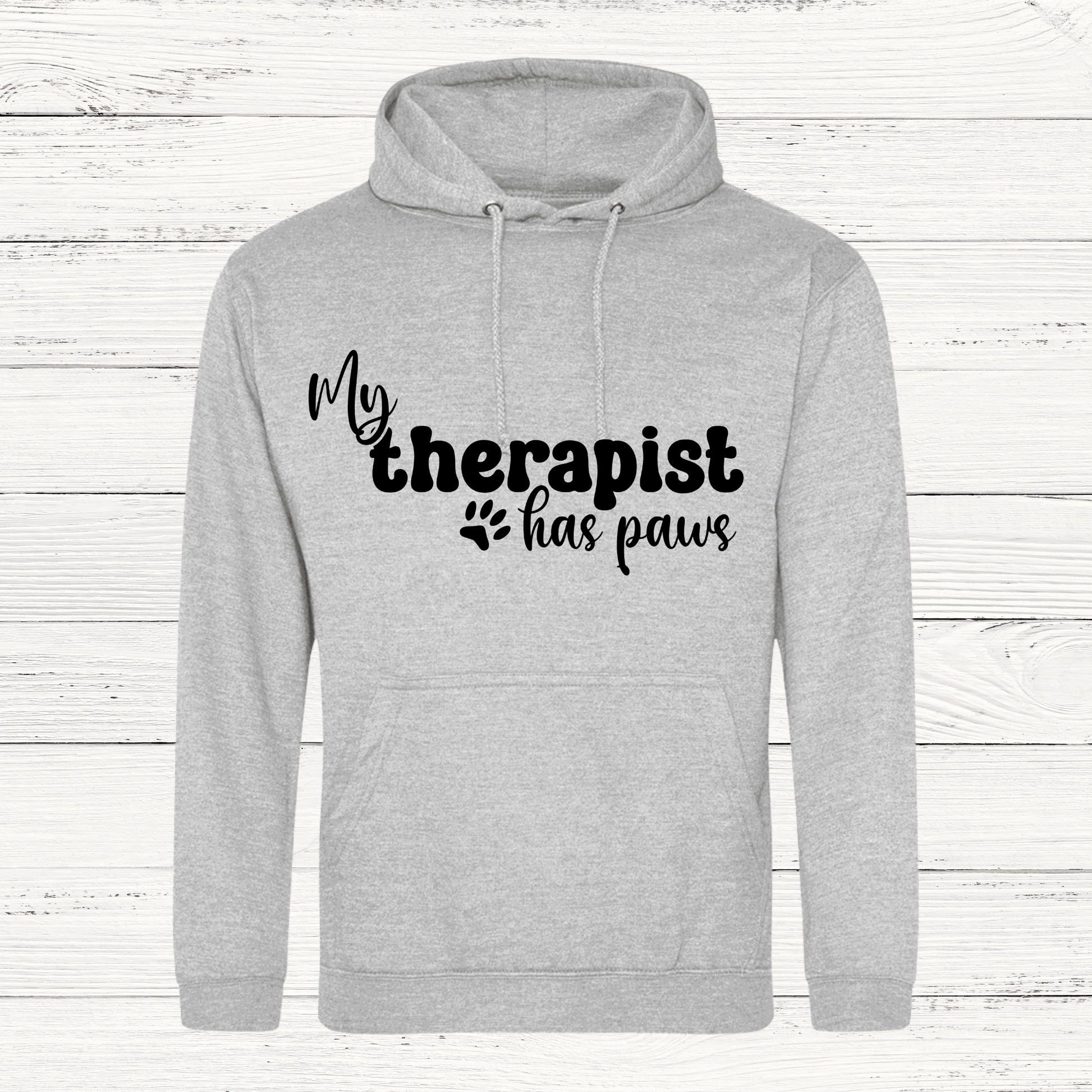 Gray hoodie with 'My therapist has paws' text on a wooden background