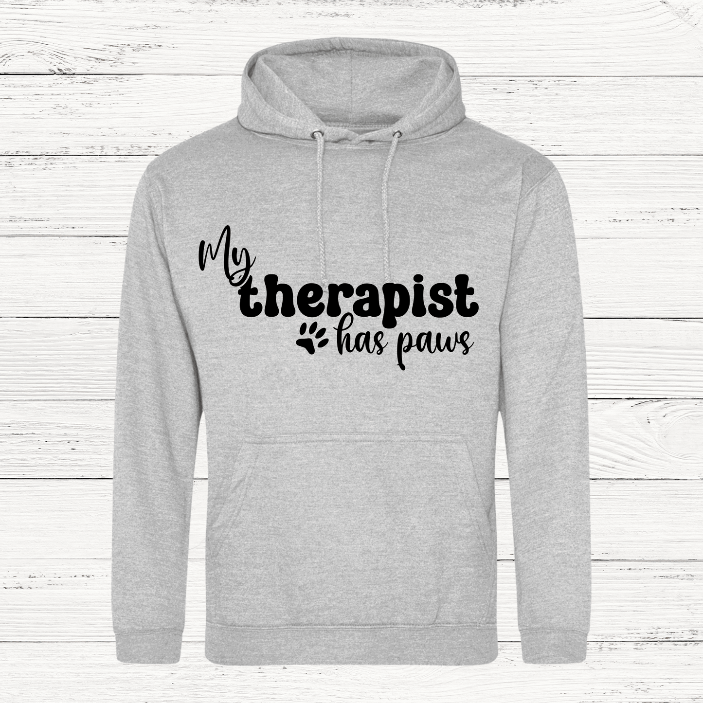 Gray hoodie with 'My therapist has paws' text on a wooden background