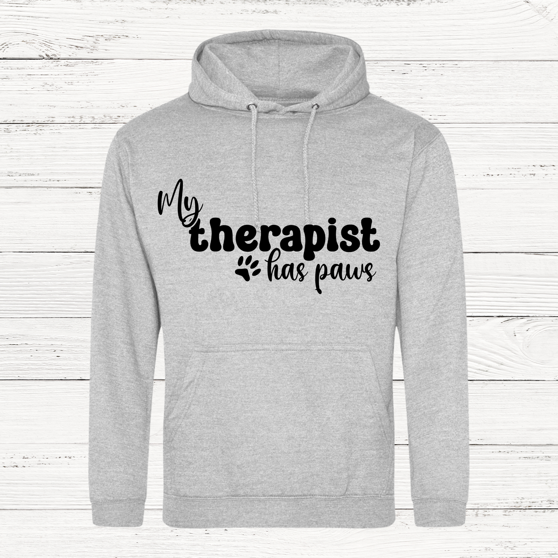 Gray hoodie with 'My therapist has paws' text on a wooden background