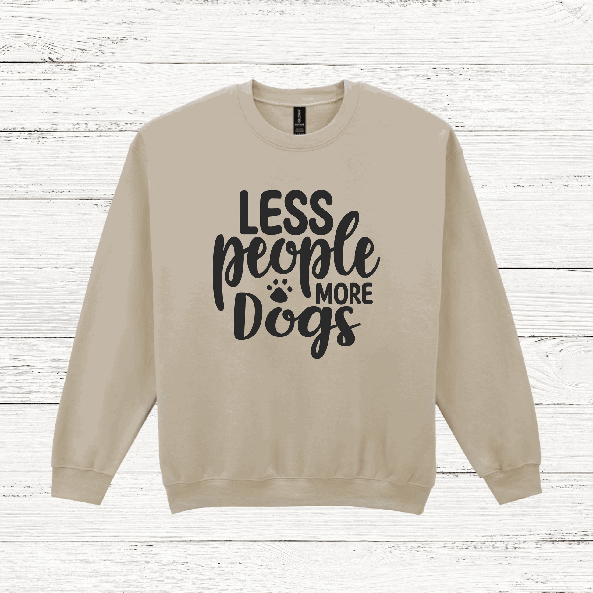 Beige sweatshirt with 'LESS people MORE Dogs' text on a wooden background