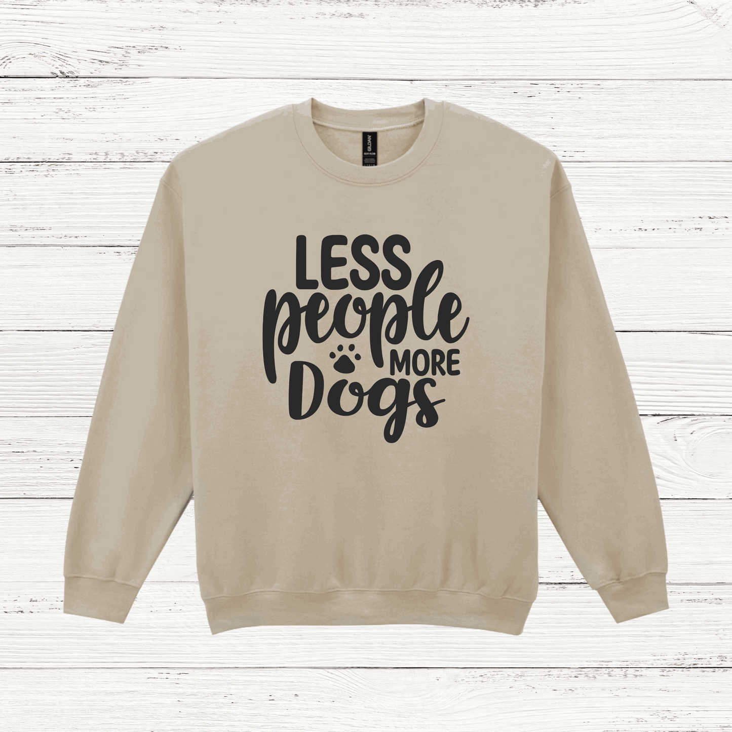 Beige sweatshirt with 'LESS people MORE Dogs' text on a wooden background