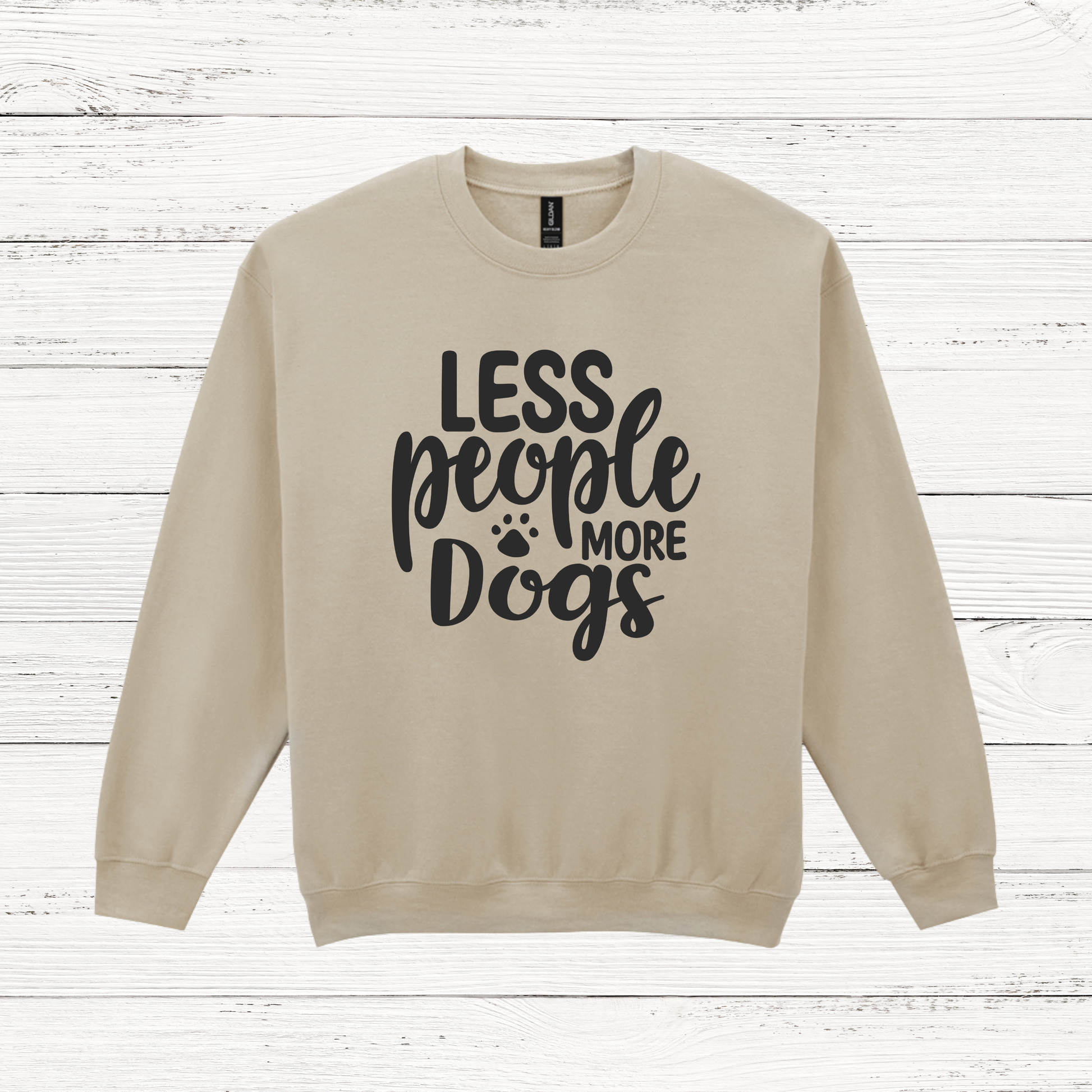 Beige sweatshirt with 'LESS people MORE Dogs' text on a wooden background