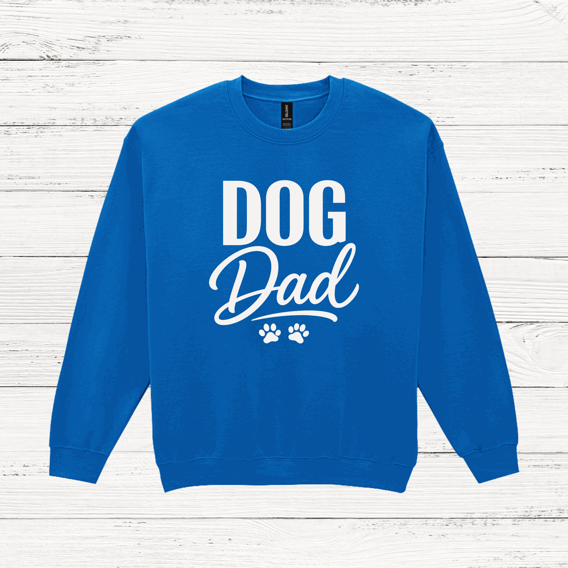 Blue sweatshirt with 'DOG Dad' text on a white wooden background