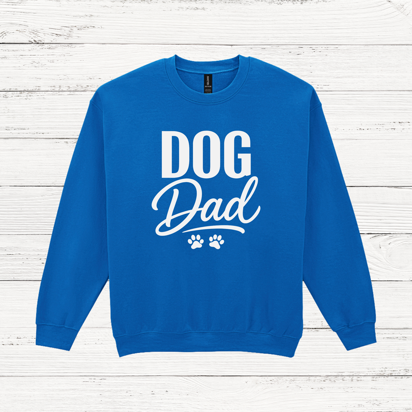 Blue sweatshirt with 'DOG Dad' text on a white wooden background