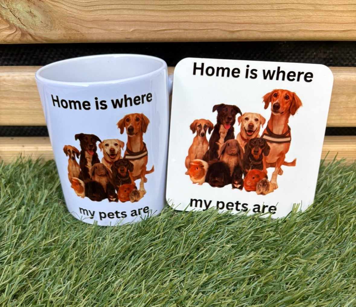 Mug and coaster set with dog illustration and 'Home is where my pets are' text on grass and wooden surface.